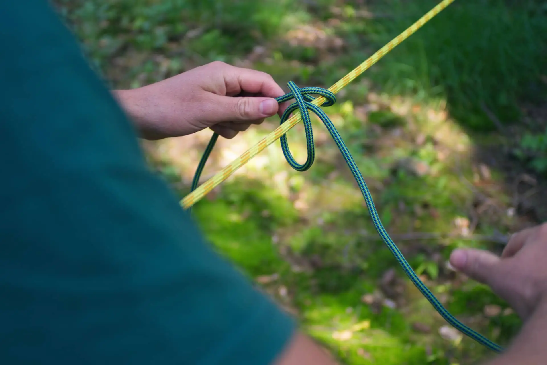 Participante practicando un nudo ballestrinque durante el curso de supervivencia y nudos y refugios de Outdoor Heroes.