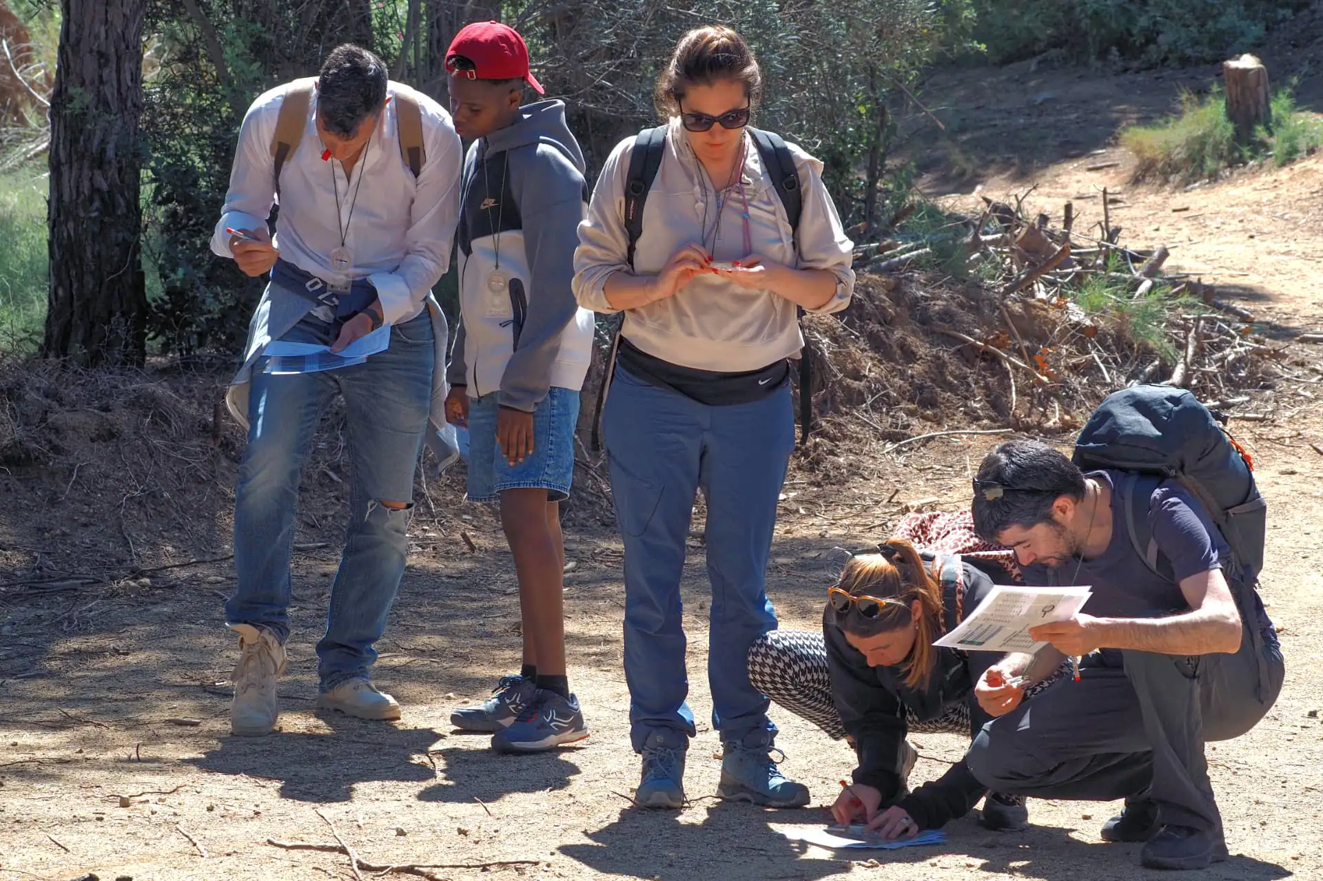 Team building y orientación: grupo de participantes colaborando con mapa y brújula al aire libre en Barcelona.
