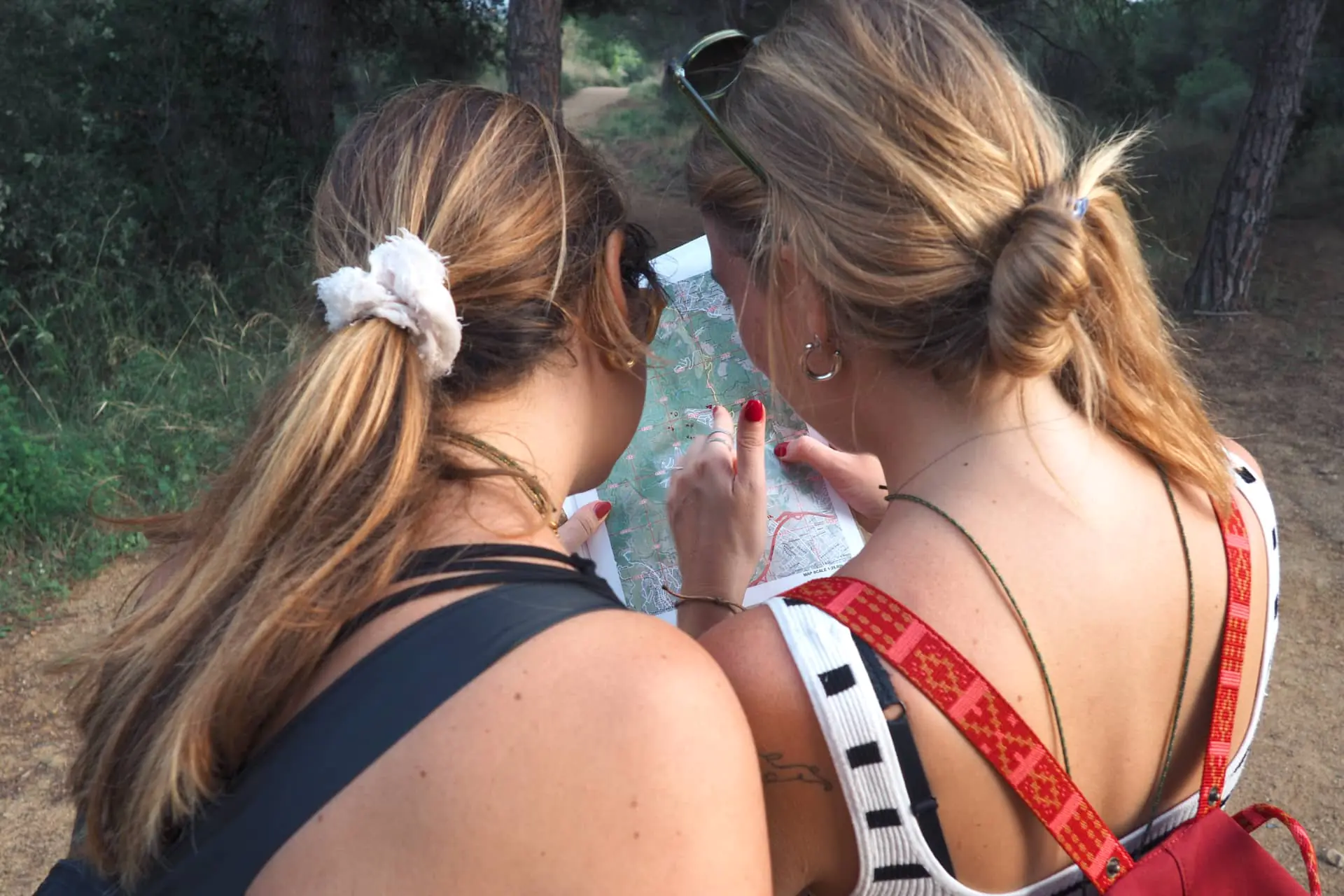 Team building navigation experience: two female participants discussing the route on a topographical map.